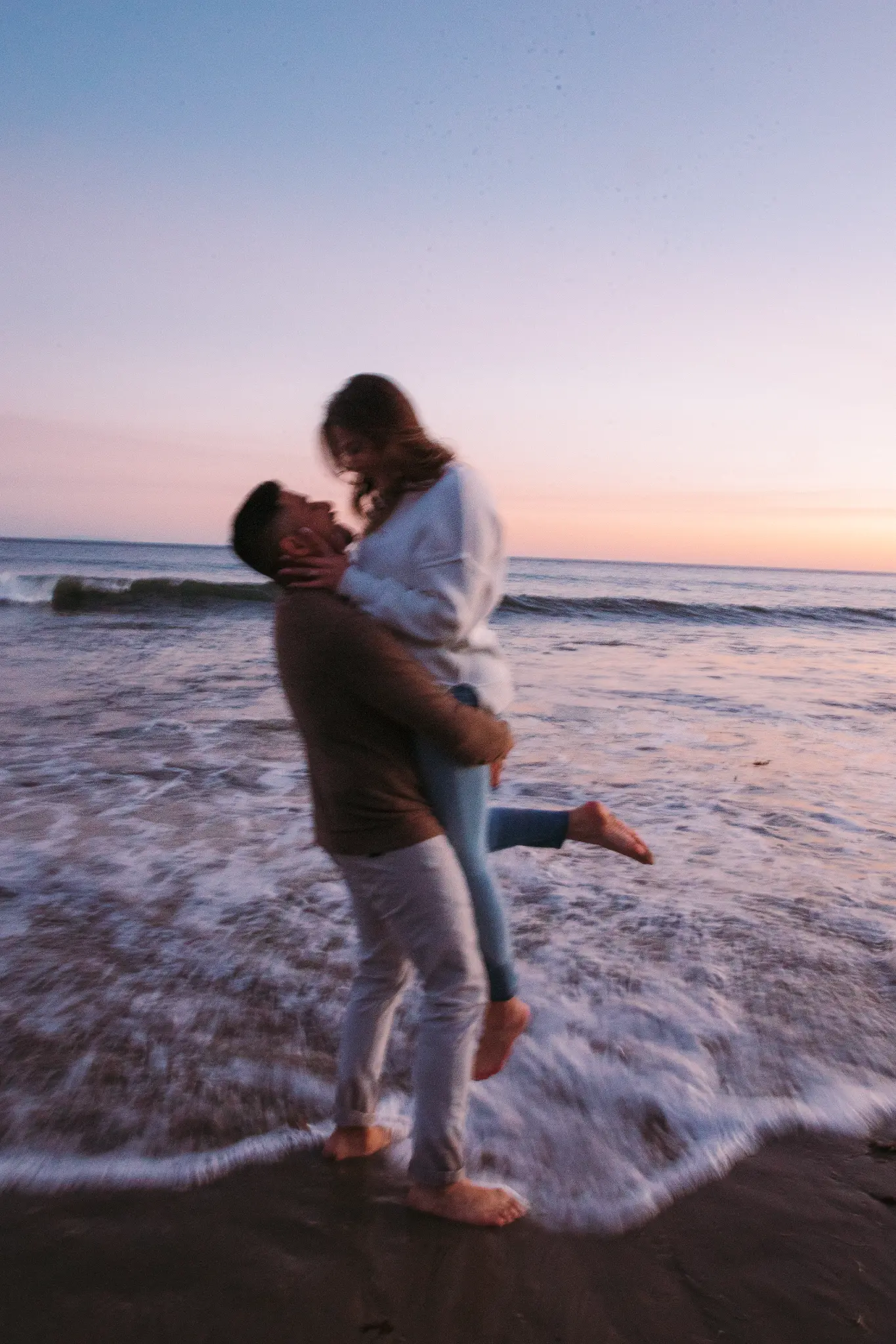 Couple in the surf at sunset.