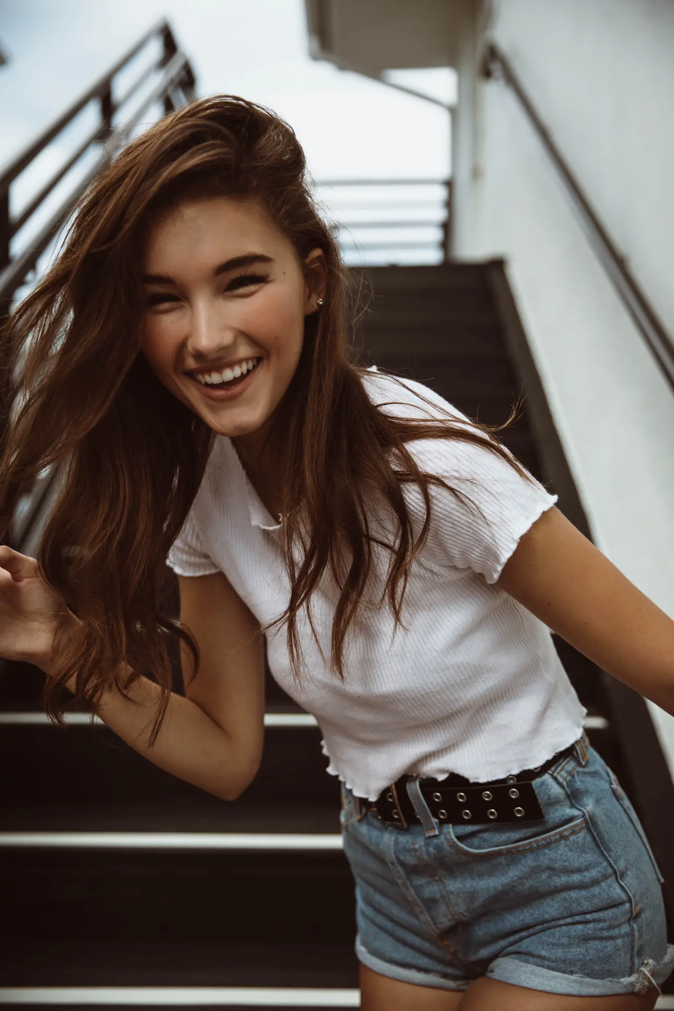 Portrait of a smiling woman on a staircase.
