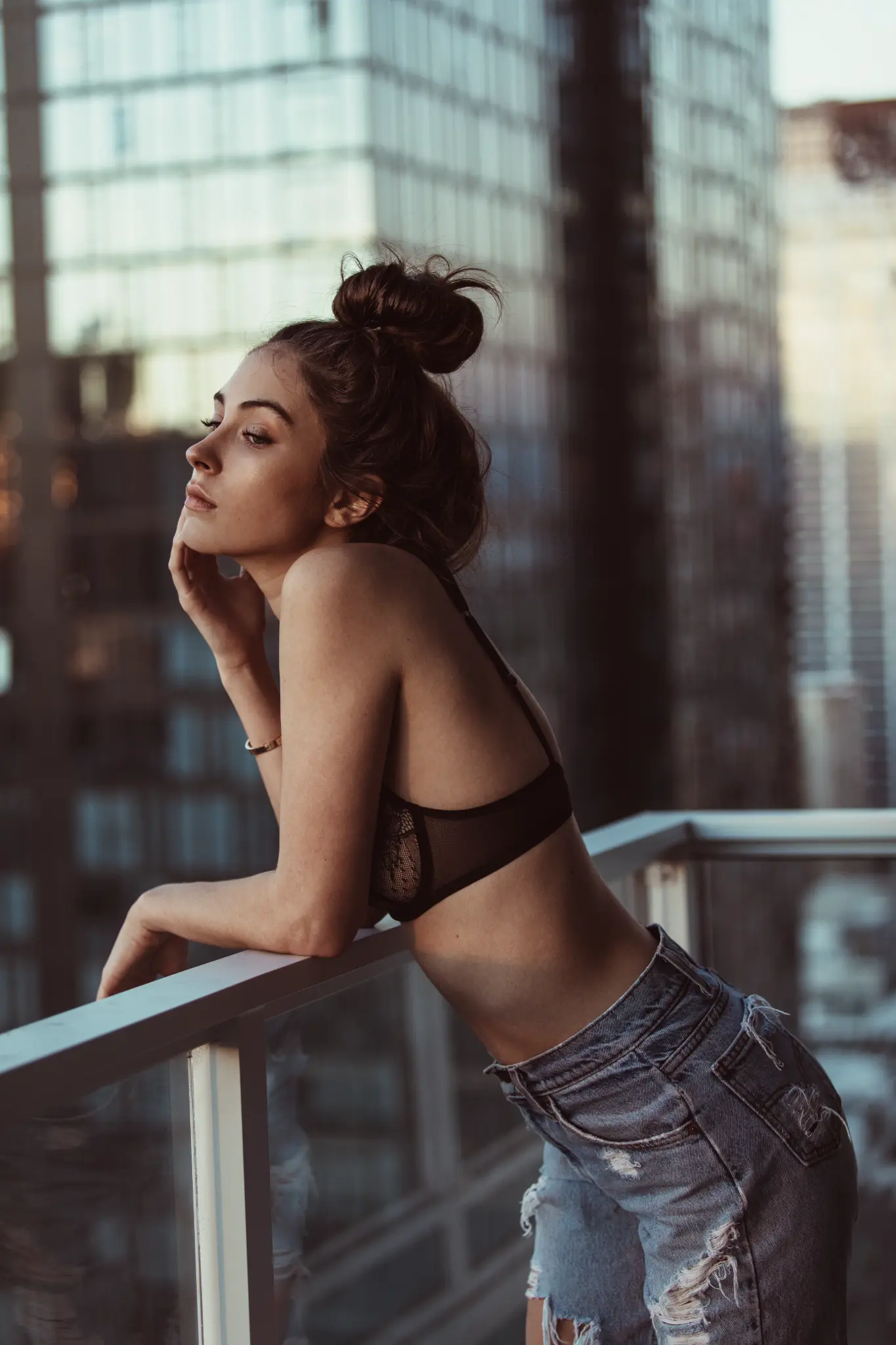 Portrait of a woman leaning on an urban balcony.