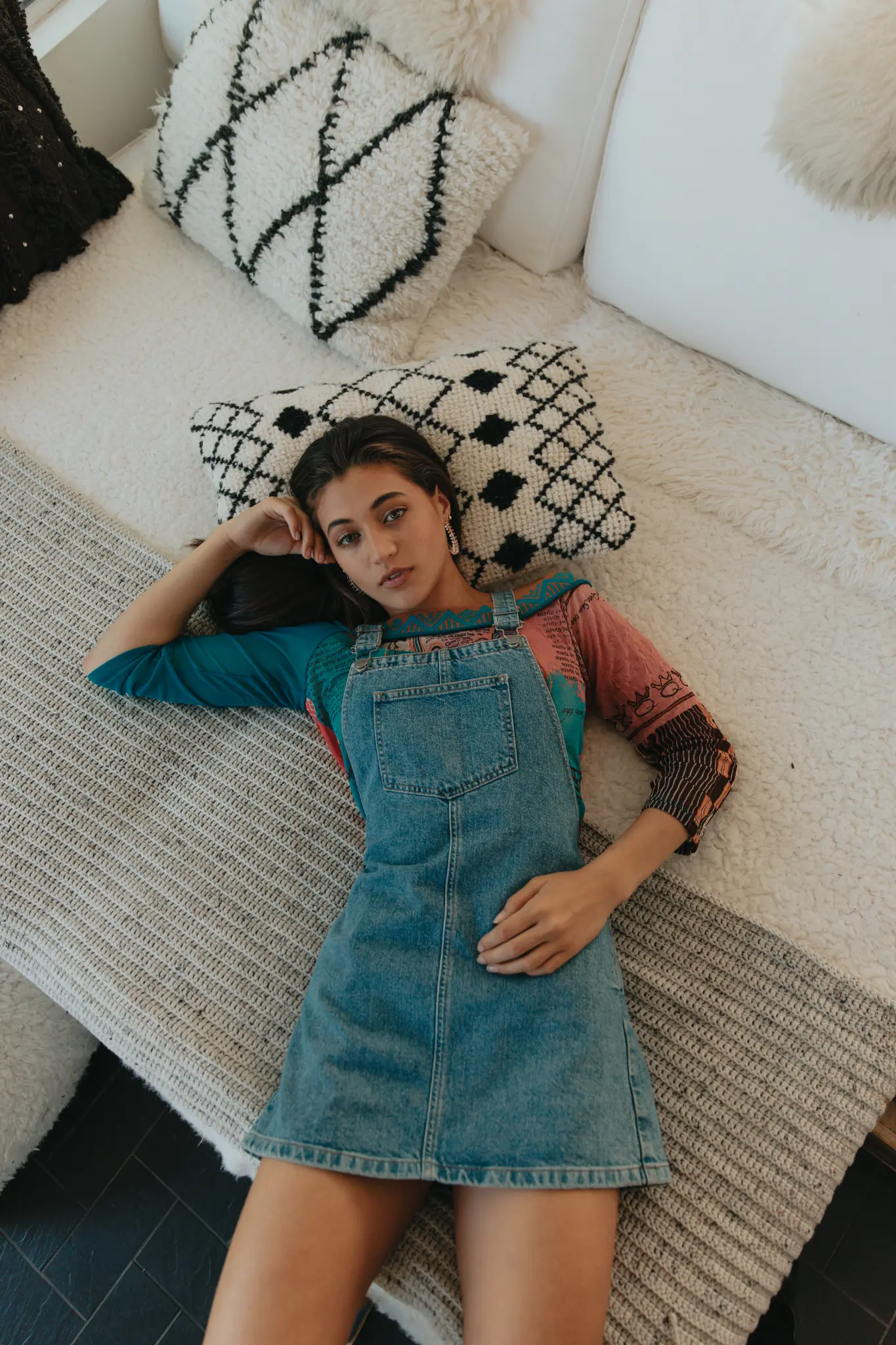 Overhead portrait of a woman reclining on a textured couch.